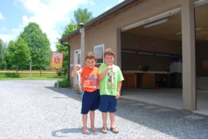Two boys standing in front of a garage.